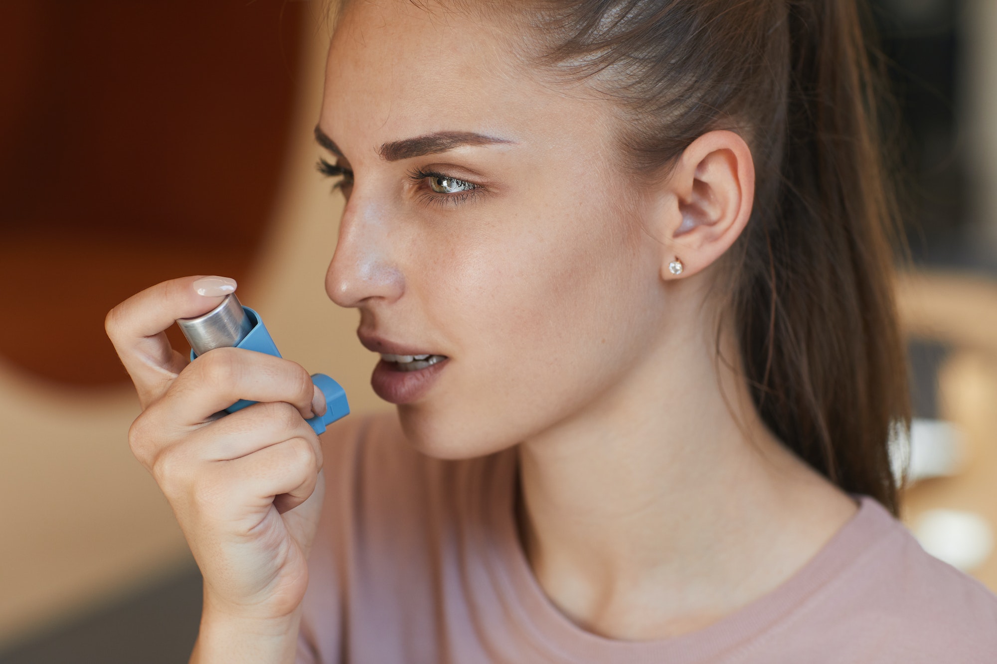 Girl using asthma inhaler